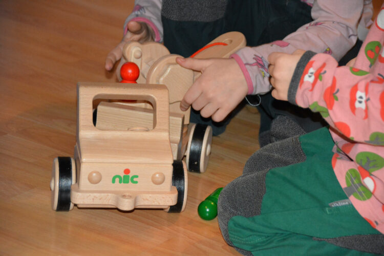 Kinder spielen mit Nic Holzspielzeug